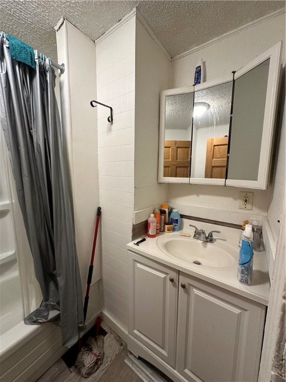 bathroom featuring vanity, hardwood / wood-style flooring, a textured ceiling, and shower / bathtub combination with curtain