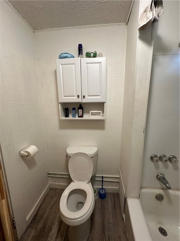 bathroom featuring tub / shower combination, wood-type flooring, a textured ceiling, and toilet