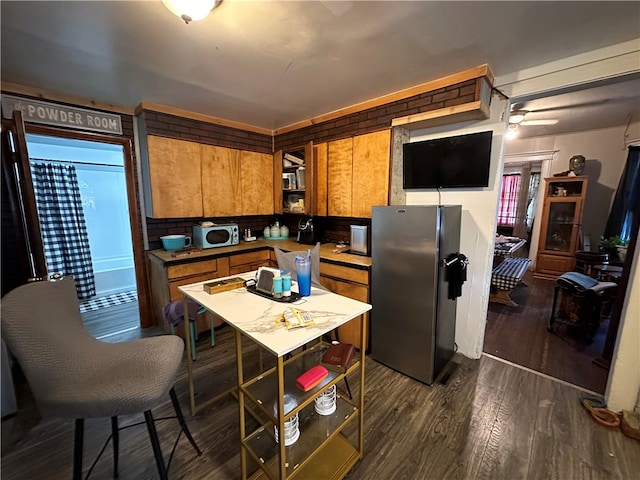 kitchen with dark hardwood / wood-style floors and stainless steel refrigerator