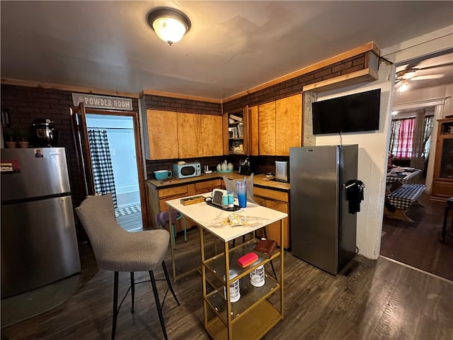 kitchen featuring dark hardwood / wood-style flooring, ceiling fan, and stainless steel fridge