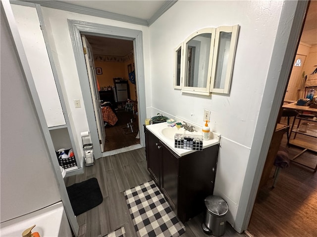 bathroom with vanity, wood-type flooring, and crown molding