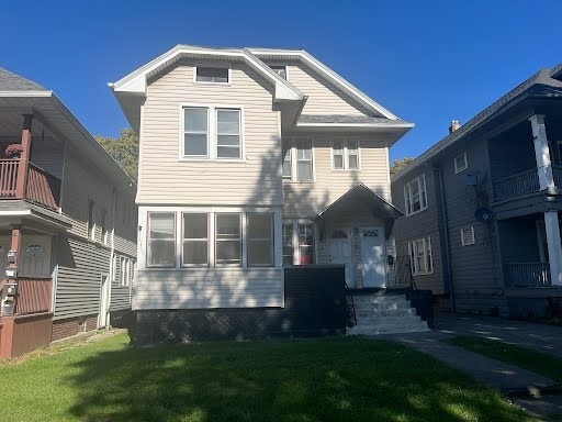 view of front of home featuring a front yard and a balcony