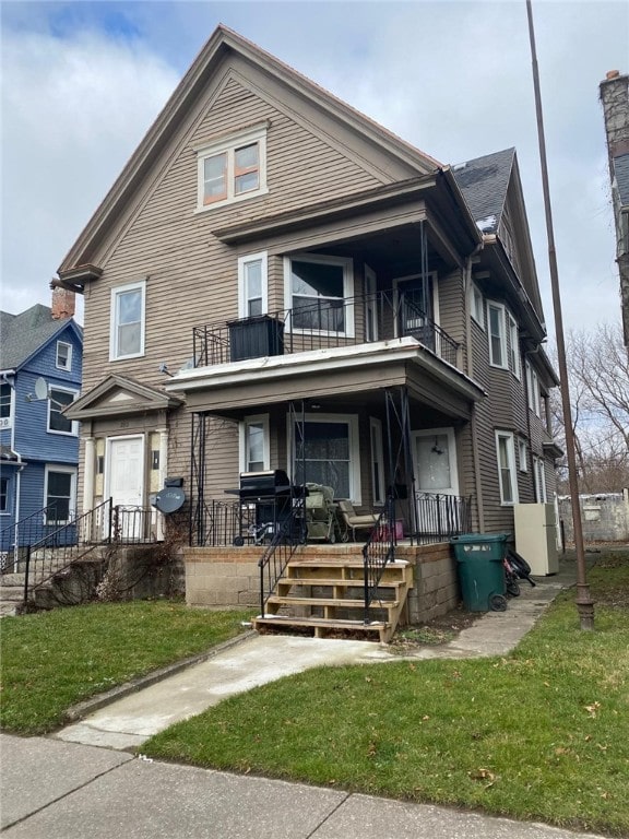 278 Tremont St, Rochester, NY 14608 - view of front facade featuring a balcony, a porch, and a front lawn