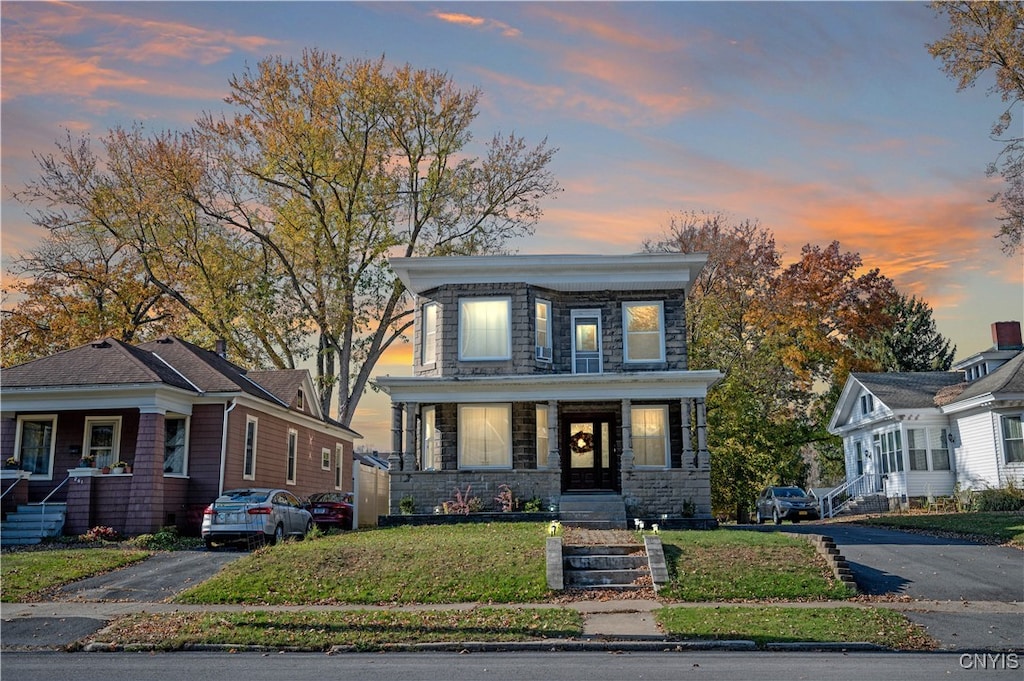 view of front facade with covered porch and a lawn