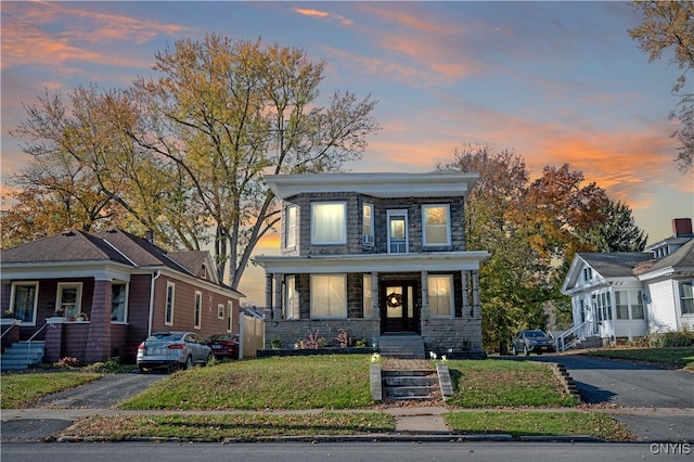 view of front facade with covered porch and a lawn