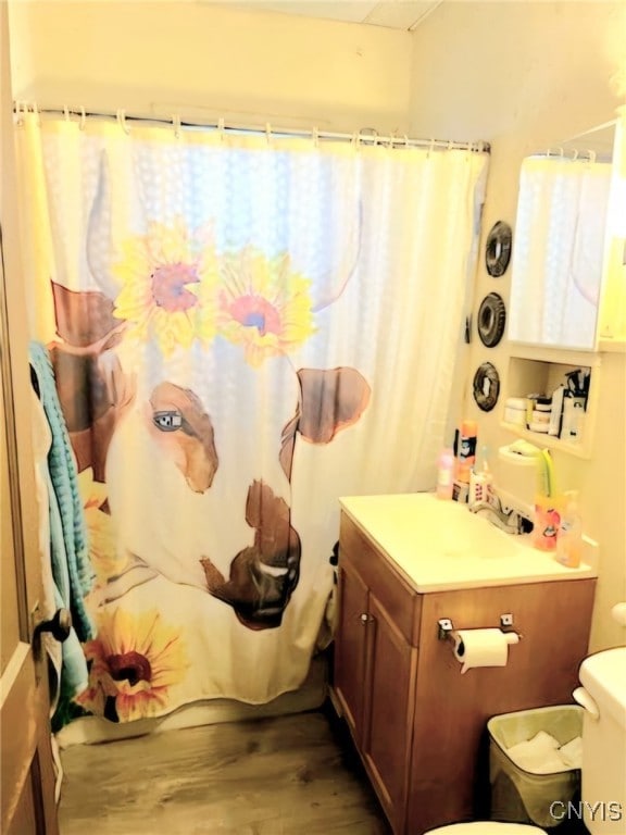 bathroom with hardwood / wood-style flooring, toilet, and walk in shower