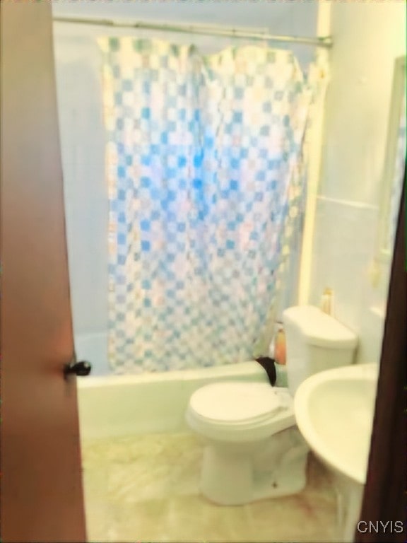 bathroom featuring shower / bath combo with shower curtain, tile patterned flooring, and toilet