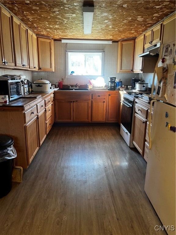 kitchen with white appliances and dark hardwood / wood-style floors