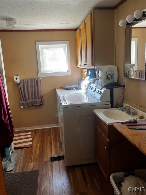 laundry room featuring dark wood-type flooring, washing machine and dryer, and sink