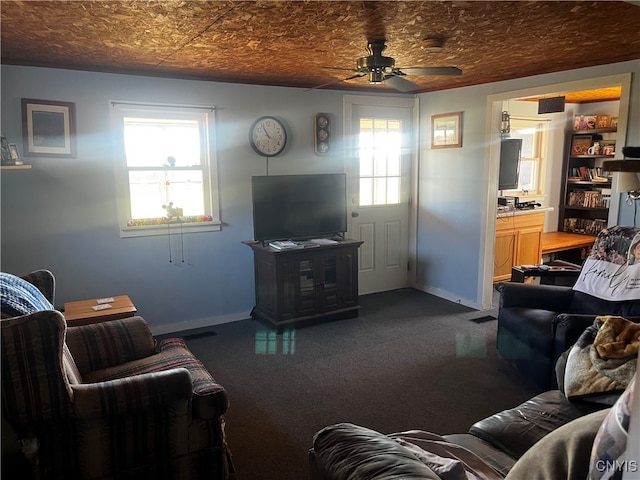 living room featuring dark colored carpet and ceiling fan