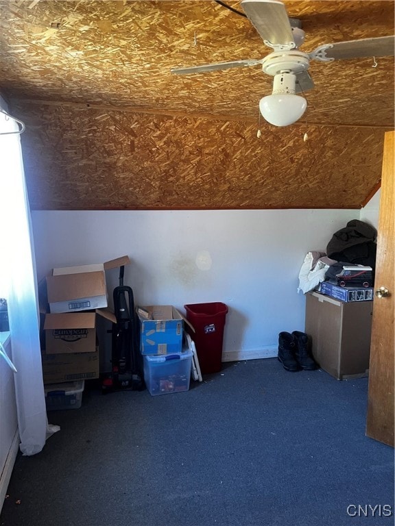 bonus room featuring ceiling fan and dark carpet