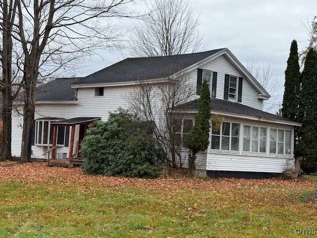 view of home's exterior featuring a sunroom and a yard