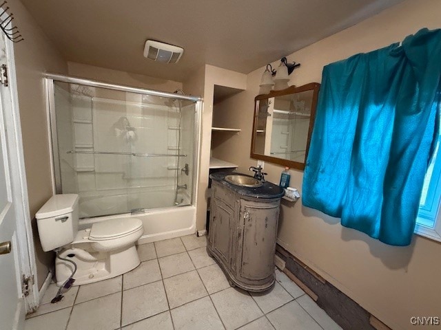 full bathroom featuring tile patterned flooring, vanity, combined bath / shower with glass door, and toilet