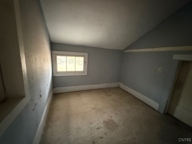 interior space featuring lofted ceiling and light carpet