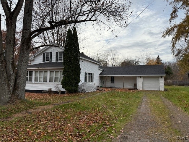 view of front facade featuring a garage, a front lawn, and a sunroom