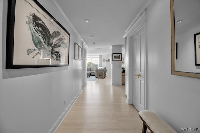 corridor featuring light hardwood / wood-style floors and crown molding