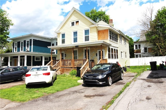 country-style home with a front yard and covered porch