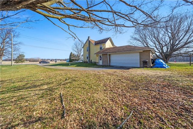 view of side of property featuring a garage and a lawn