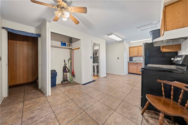 kitchen with crown molding, light tile patterned floors, ceiling fan, and washer / dryer