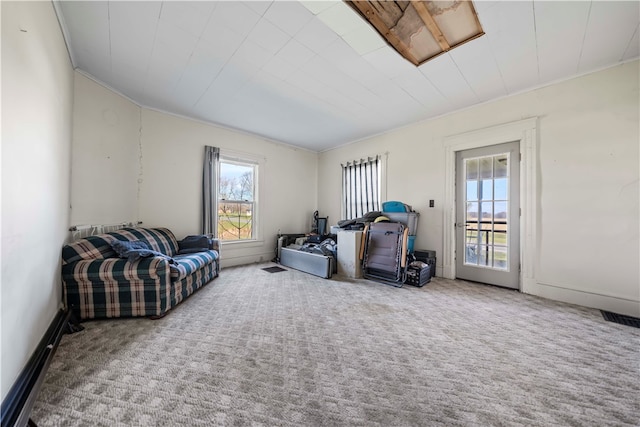 living room featuring plenty of natural light, carpet floors, and ornamental molding