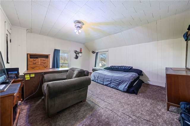 carpeted bedroom featuring wooden walls, vaulted ceiling, and ceiling fan