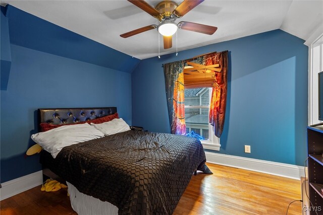 bedroom with hardwood / wood-style flooring, ceiling fan, and lofted ceiling