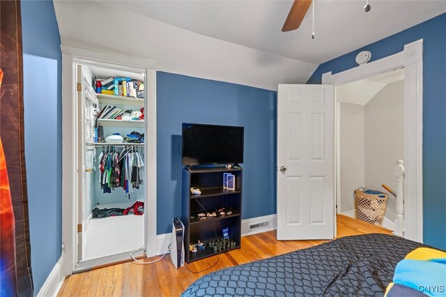 bedroom featuring wood-type flooring, ceiling fan, lofted ceiling, and a closet