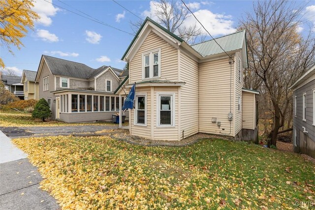 view of front of home featuring a sunroom and a front yard