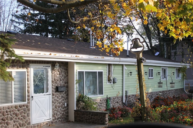 rear view of house with stone siding