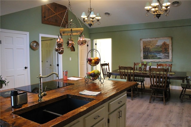 kitchen with butcher block counters, light hardwood / wood-style flooring, sink, and white cabinets