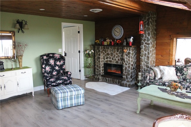 living room featuring wood ceiling, hardwood / wood-style flooring, and a fireplace