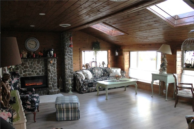 living room featuring wooden ceiling, hardwood / wood-style flooring, and vaulted ceiling with skylight