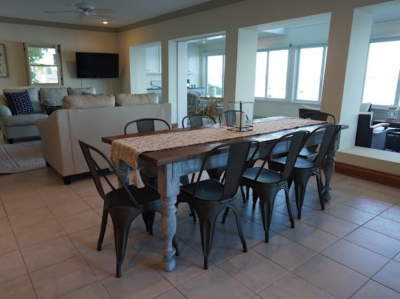 dining room featuring ceiling fan, crown molding, and light tile patterned floors