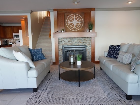 living room featuring light tile patterned flooring and a stone fireplace