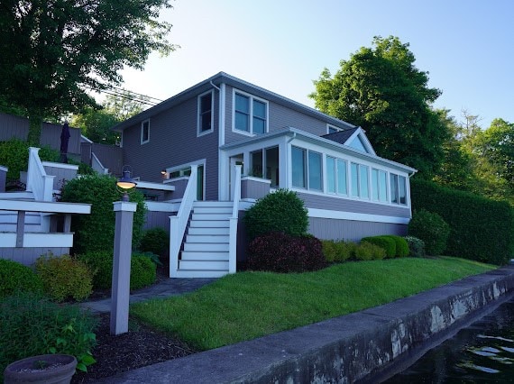 view of front facade with a front lawn and a sunroom