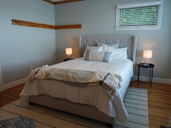 bedroom featuring hardwood / wood-style floors and crown molding