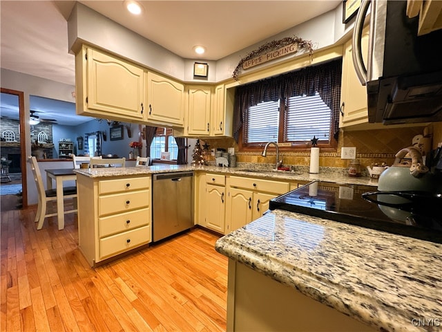 kitchen with light hardwood / wood-style floors, sink, kitchen peninsula, ceiling fan, and dishwasher