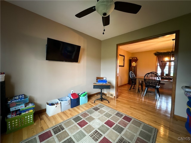 interior space with hardwood / wood-style flooring and ceiling fan with notable chandelier