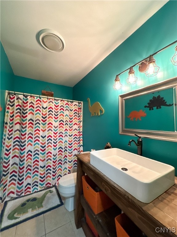 bathroom featuring a shower with curtain, tile patterned floors, toilet, and sink