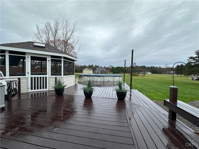 wooden terrace with a sunroom, a yard, and a covered pool