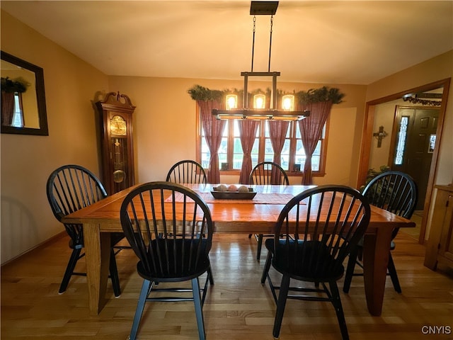 dining space with hardwood / wood-style flooring and a chandelier