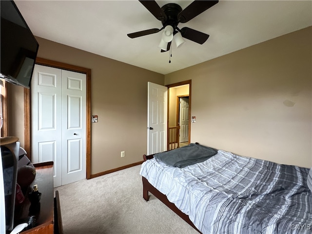 carpeted bedroom with ceiling fan and a closet