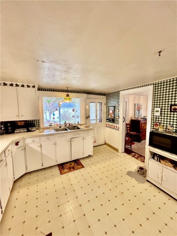 kitchen featuring white cabinets, a textured ceiling, and sink