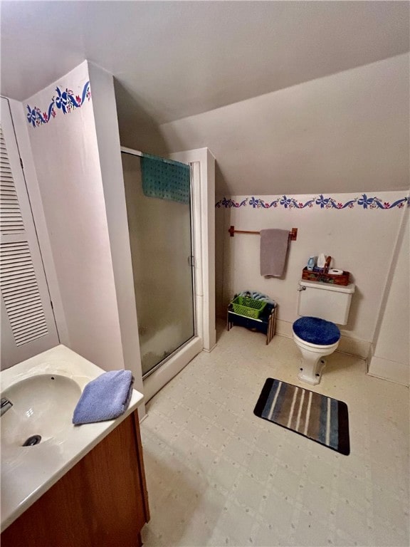 bathroom with lofted ceiling, toilet, a shower with shower door, and vanity