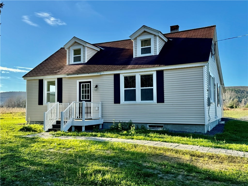 cape cod home with a front lawn