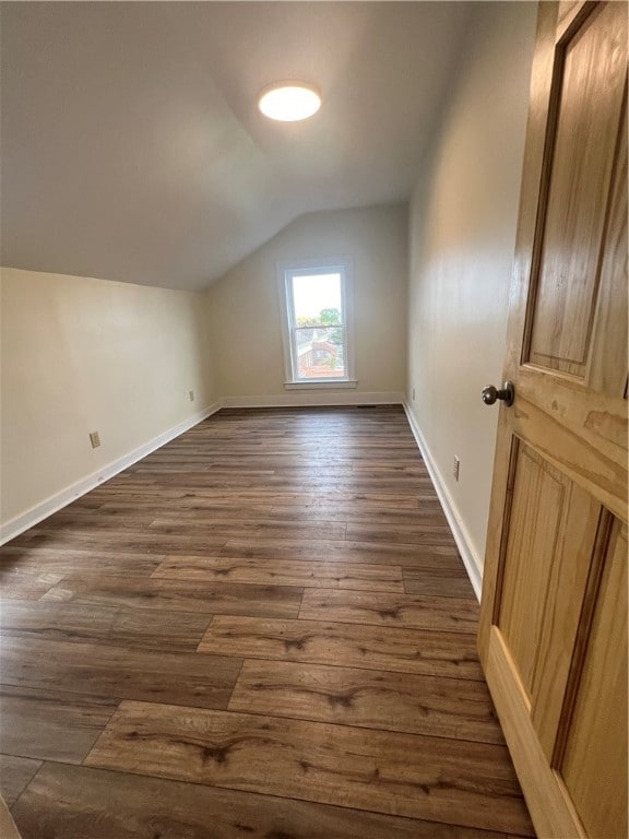 bonus room with vaulted ceiling and dark hardwood / wood-style flooring