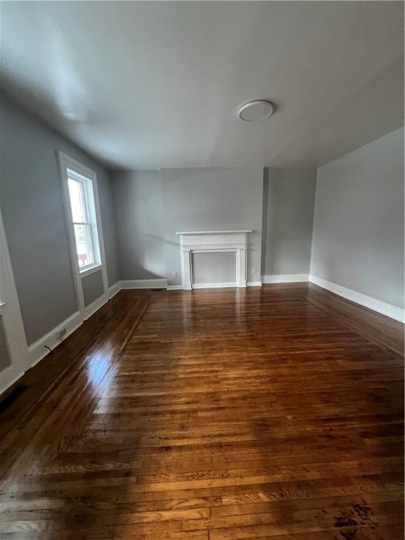 unfurnished living room with dark hardwood / wood-style floors and a fireplace