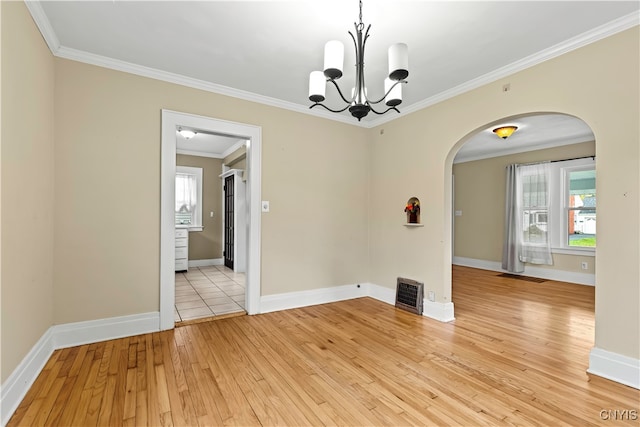 spare room featuring a chandelier, ornamental molding, and light hardwood / wood-style flooring