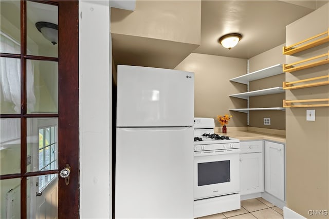 kitchen with white cabinetry, light tile patterned floors, and white appliances