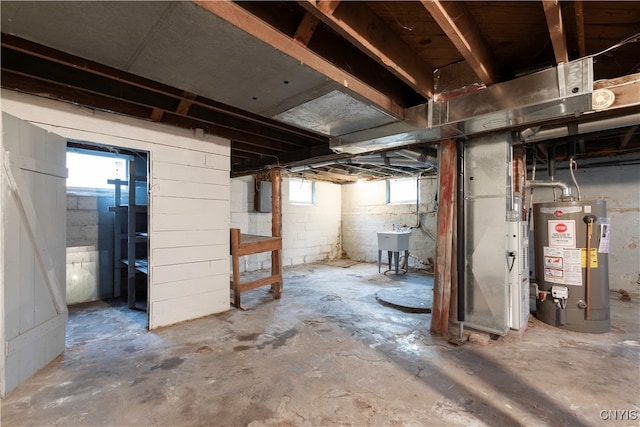 basement featuring electric panel, water heater, and sink